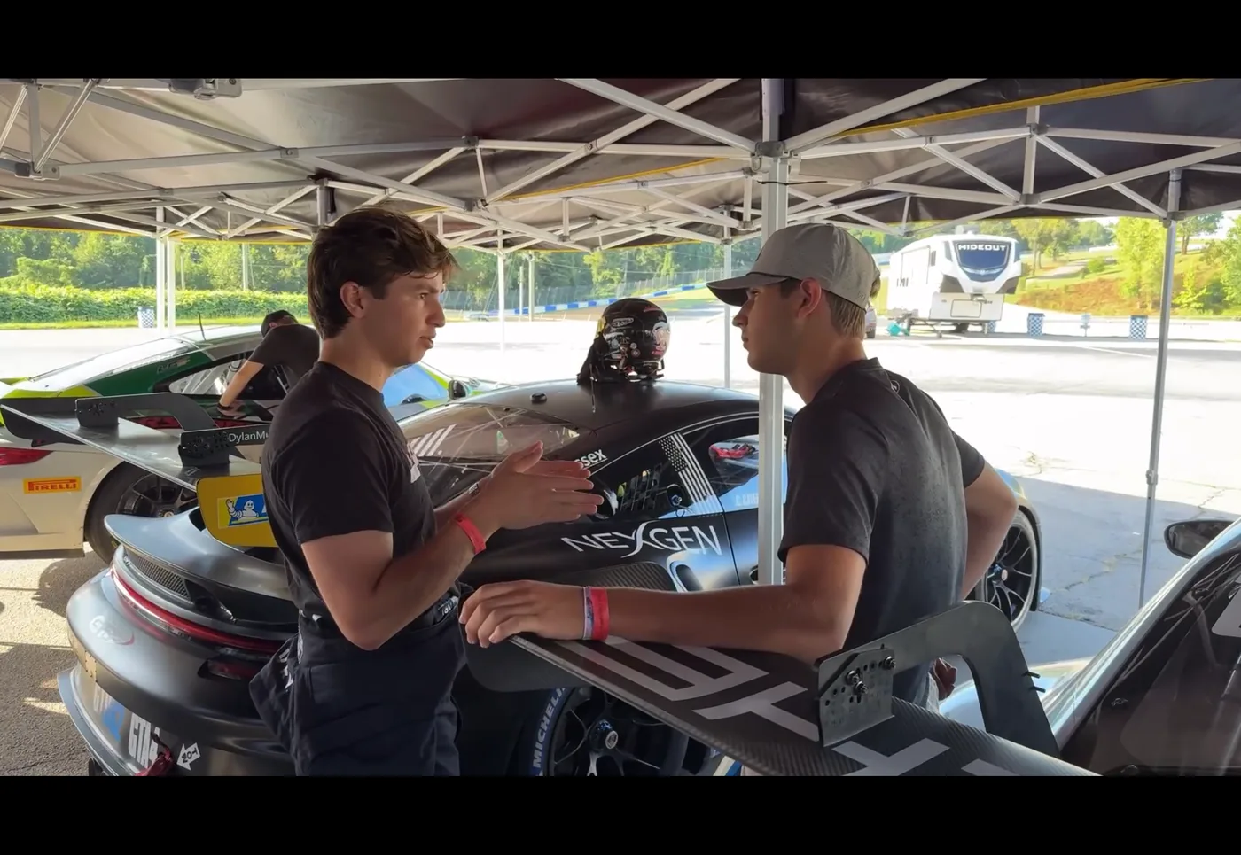 Liam Gray talking through a session with his driving coach in the paddock