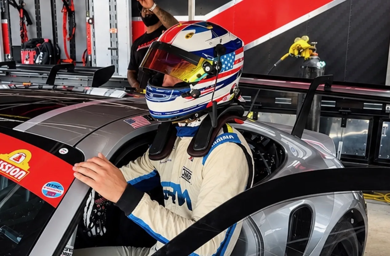 Liam Gray helmeted and getting into the car in the garage